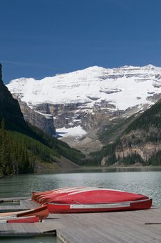 Canoes at Lake Louise with Victoria glacier in the background