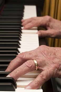 Selective focus on old hands playing the piano 