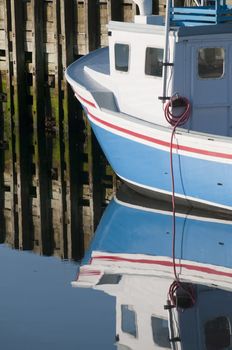 Portion of lobster boat reflection in the early morning harbour area
