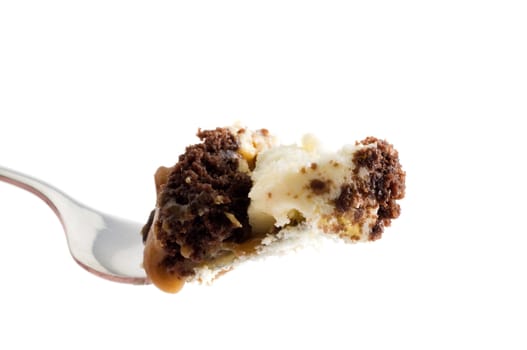 Macro image of a fork full of carmel pecan cheesecake