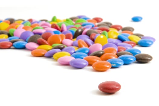 Selective focus on the foreground red coloured candy coated chocolate.