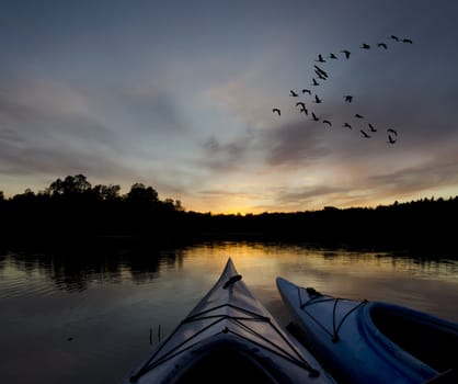 Two kayaks at sunset with the geese coming to land on the bay area of Charleston Lake