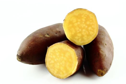 cutting sweet potatoes on white background