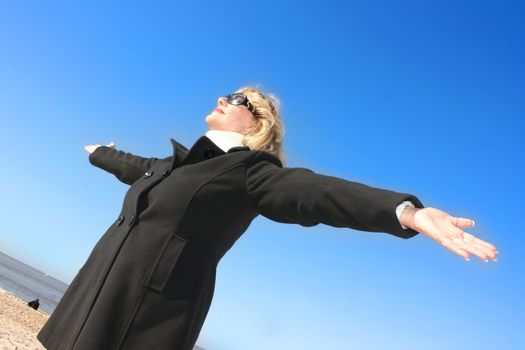 Portrait of a mature woman enjoying the sunlight on a beach.