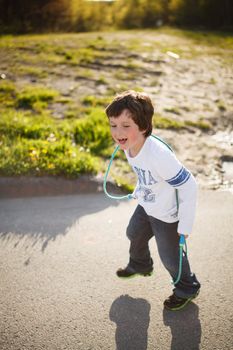 Cute little boy playing jump rope