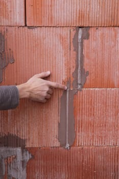 Man pointing out problem with wall