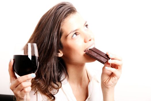 Portrait of a beautiful, latin Woman drinking red wine and eating chocolate.