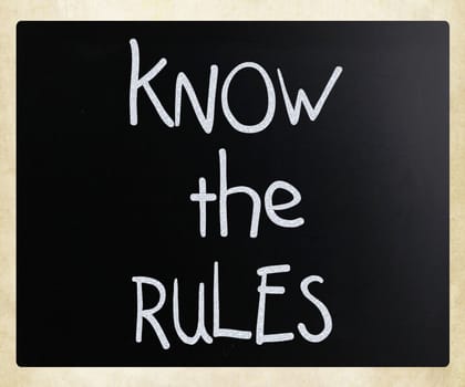 "Know the rules" handwritten with white chalk on a blackboard