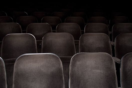 Empty chairs at cinema or theater. Gray toned