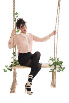 A woman in a pink blouse sitting on a swing isolated white background
