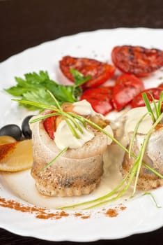 fillet of pikeperch stuffed with trout fish with baked pepper, tomato and leek