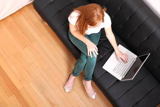 A young, brazilian woman surfing on the Internet with a Laptop.  