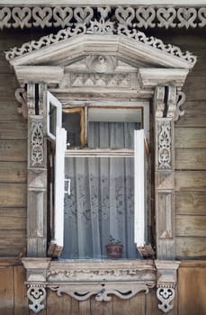 Opened old wooden window, decorated with carving