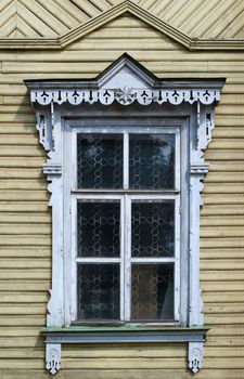 Window with carved architraves of old wooden house