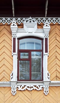 Window with decorated architraves of old wooden house