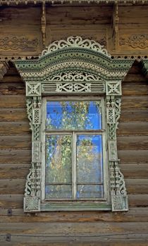 Window with carved architraves in old wooden house