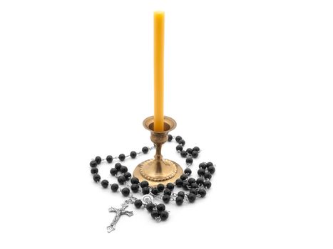 candle in bronze candlestick, rosary on white background 