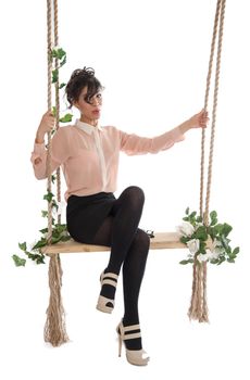 A woman in a pink blouse sitting on a swing isolated white background