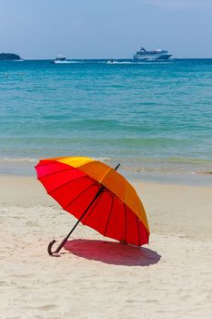 Orange umbrella on the beach in Thailand