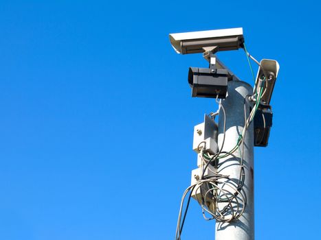 Surveillance cameras against blue sky