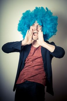 vintage portrait of fashion guy with curly blue wig on gray background