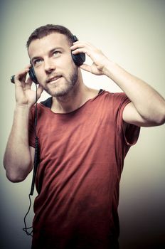 vintage portrait of fashion guy with headphones on gray background