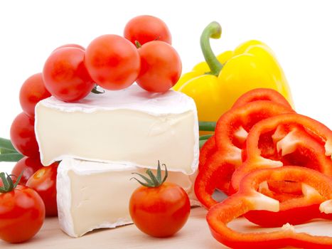 Wheel of French cheese with vegetables, on white background