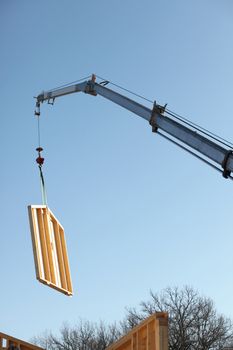 Crane lifing large wooden panel into place