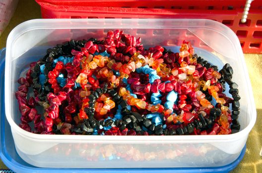 Plastic box loaded with colorful jewelry beads.