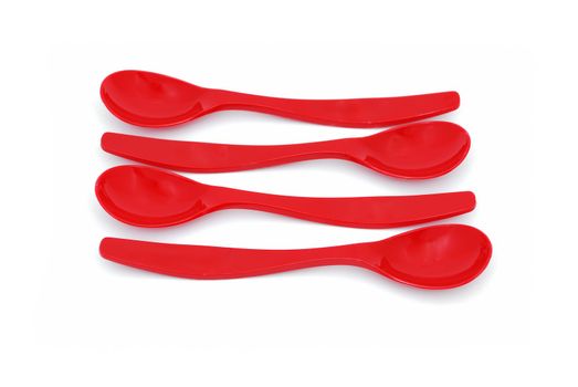 four children's spoons laid out in parallel on a white background