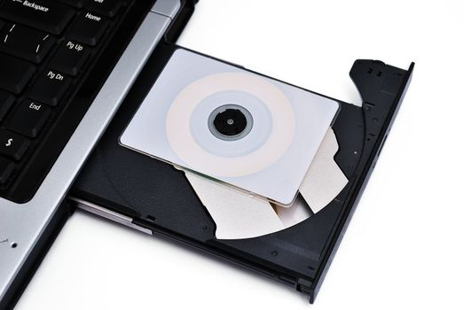The laptop is loaded with a DVD drive on a white background