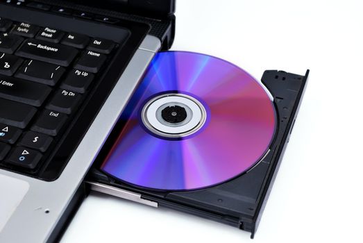 The laptop is loaded with a DVD drive on a white background