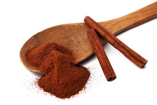 wooden spoon with cinnamon and a few tubes of cinnamon