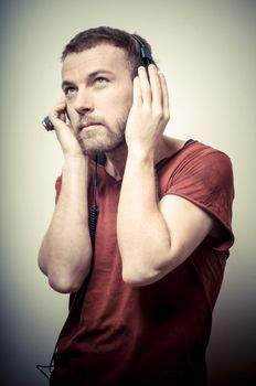 vintage portrait of fashion guy with headphones on gray background