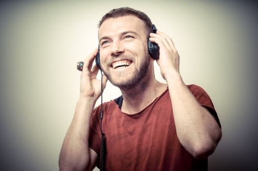 vintage portrait of fashion smiling guy with headphones on gray background