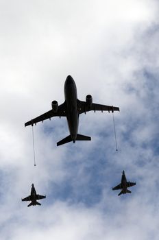 Inflight re-fueling between two fighter jets and transport fueling jet 