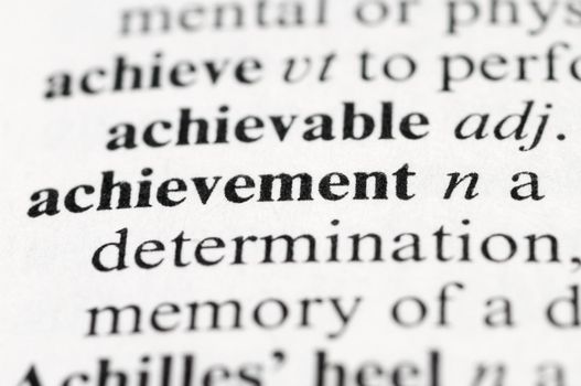 Dictionary macro photo with selective focus on the word Achievement