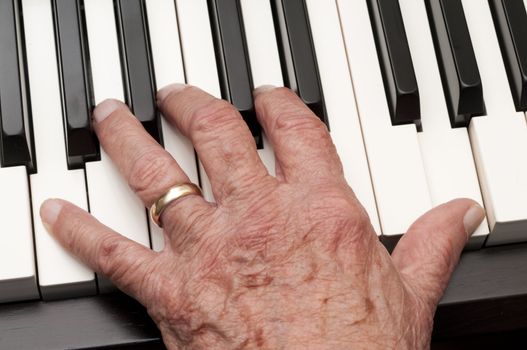 Hand of an older man playing the piano