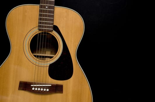 Acoustic Guitar on black background.