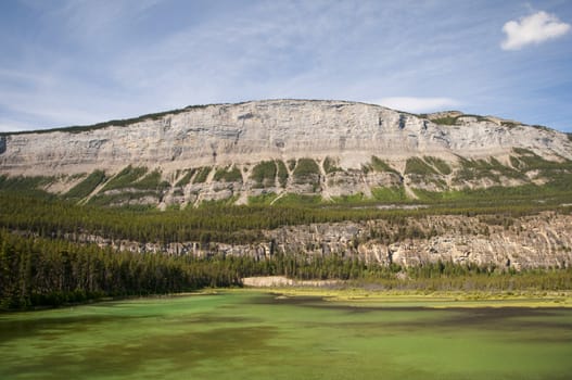 Extreme color in the lake in Jasper National Park with mountain range in the background