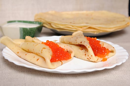 two pancake with red caviar on plate