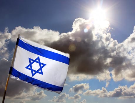 Israeli flag on the background of alarming cloudy sky