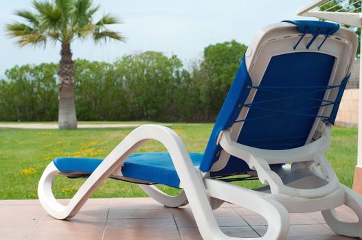 Shot of blue chaise longe near apartments