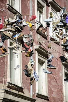 LJUBLJANA, SLOVENIA - MARCH 21: Artistic instalation of worn out shoes hanging from a cable above street, March 21, 2013 in Ljubljana, Slovenia. 