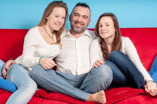 happy father and daughters on the couch in the living room