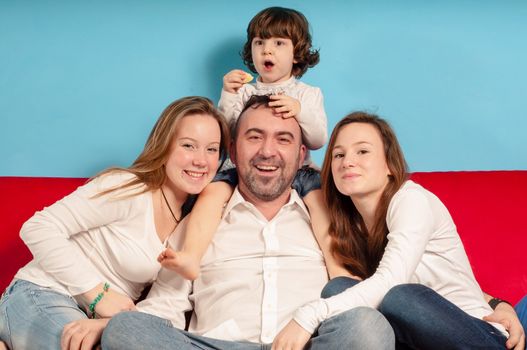 happy father and daughters on the couch in the living room