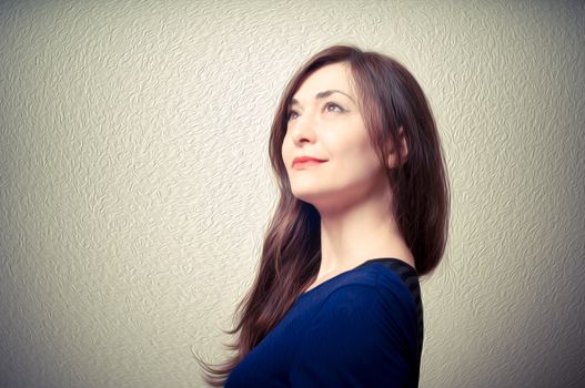 portrait of beautiful girl with long hair and blue sweater on gray background