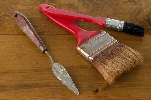 Closeup of clean used Art brushes and spatula on wooden background.