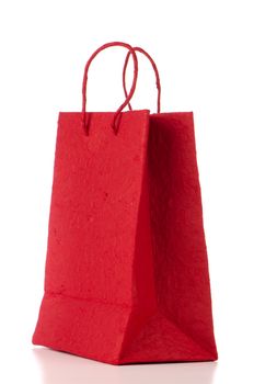 Red  paper bag over white background.
