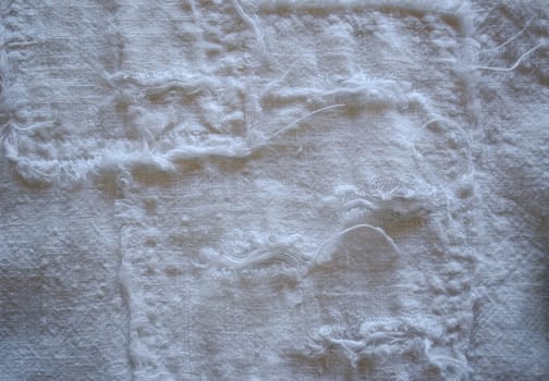 linen pant fabric closeup with long messy thread twist background.
